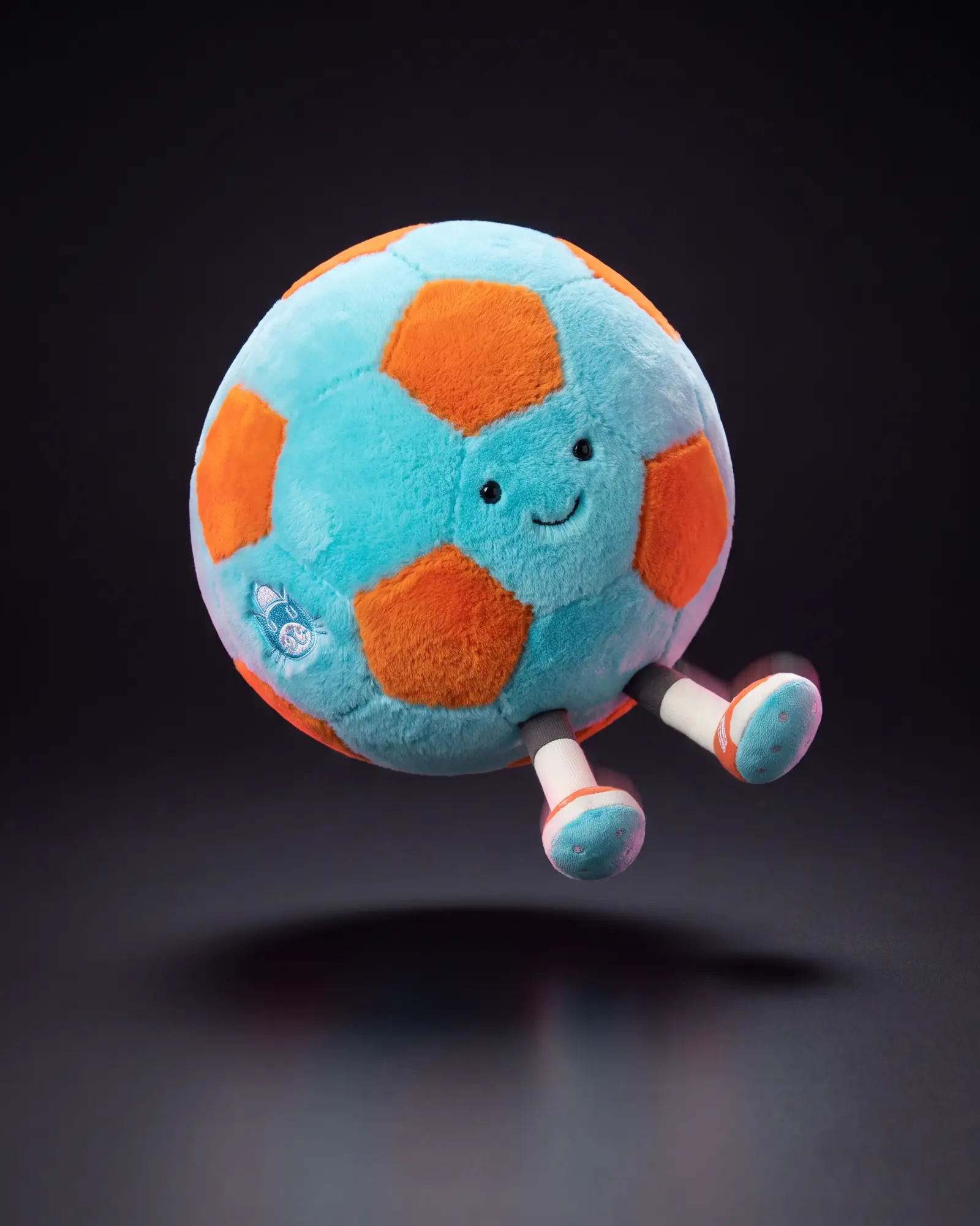 Amuseables Jellycat Football on a dark studio background.
