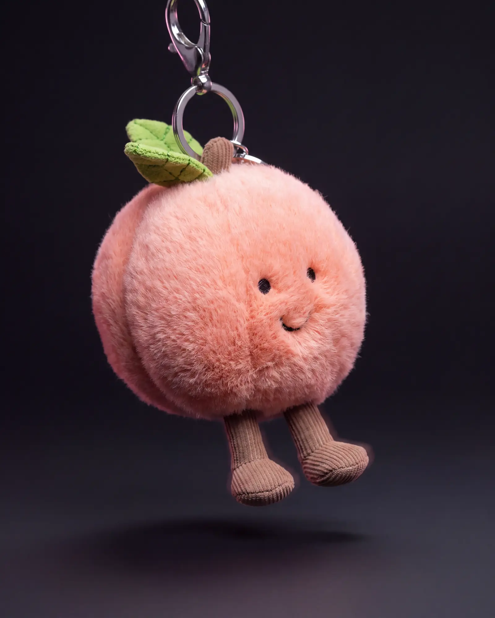 Amuseables Peach Bag Charm on a dark studio background.