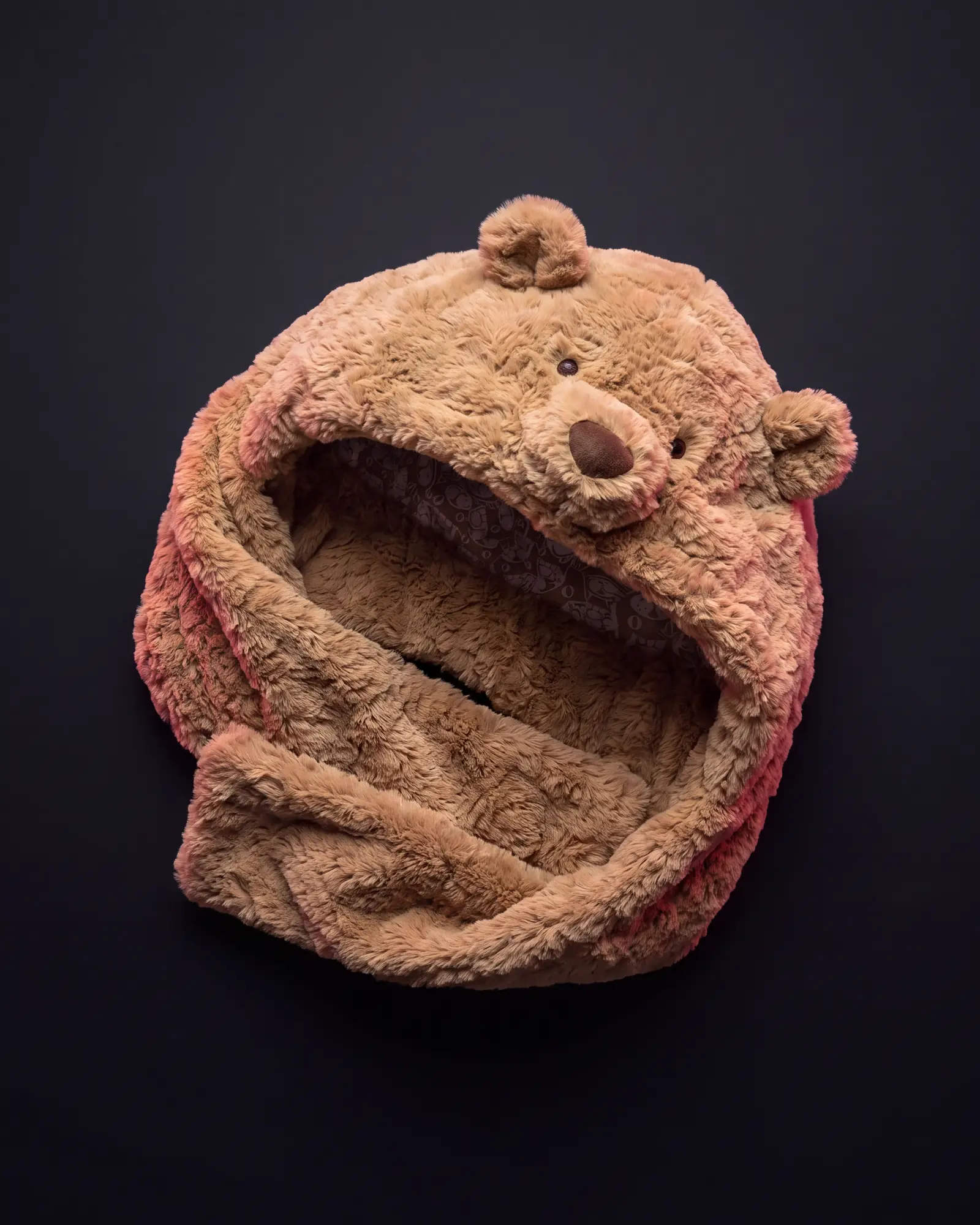 Bartholomew Bear Bundlesnug on a dark studio background.