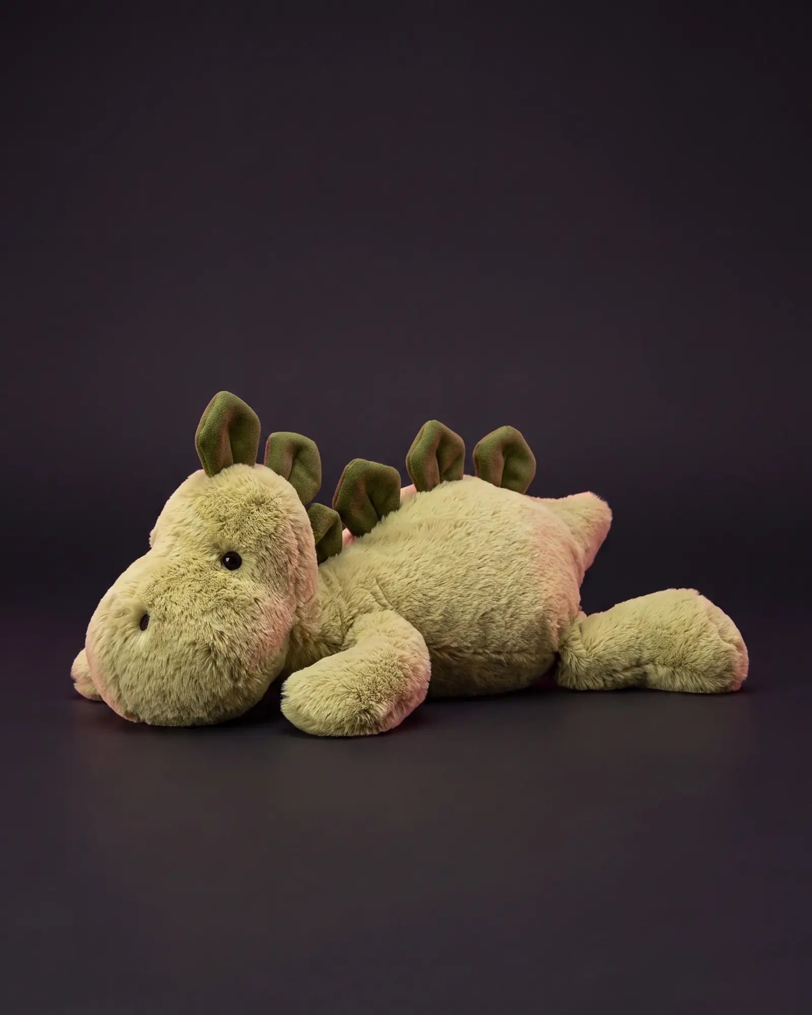 Bashful Dino on a dark studio background.