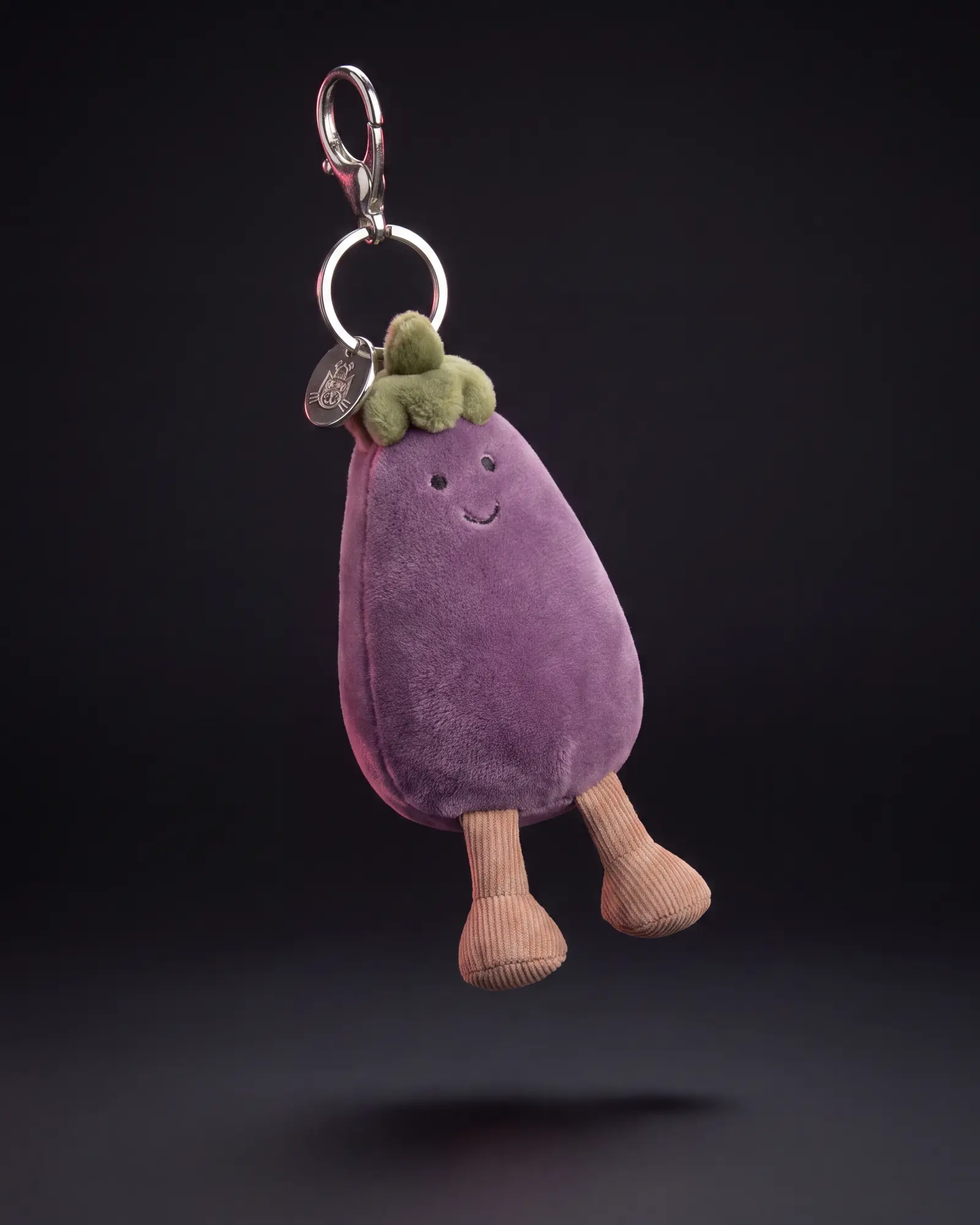 Amuseables Aubergine Bag Charm on a dark studio background.